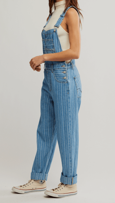 Person wearing blue striped overalls on a plain background