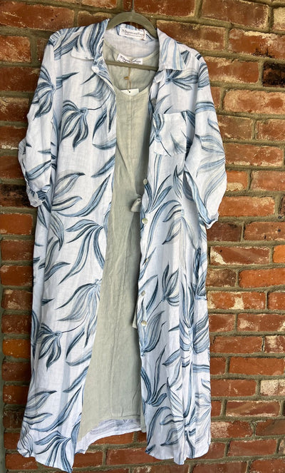 Long floral-patterned coat hanging against a brick wall