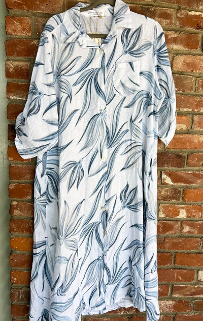 White shirt with blue leaf pattern hanging against a brick wall
