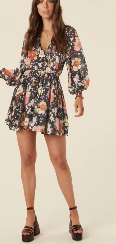 Brown haired girl facing forward with a black floral mini dress